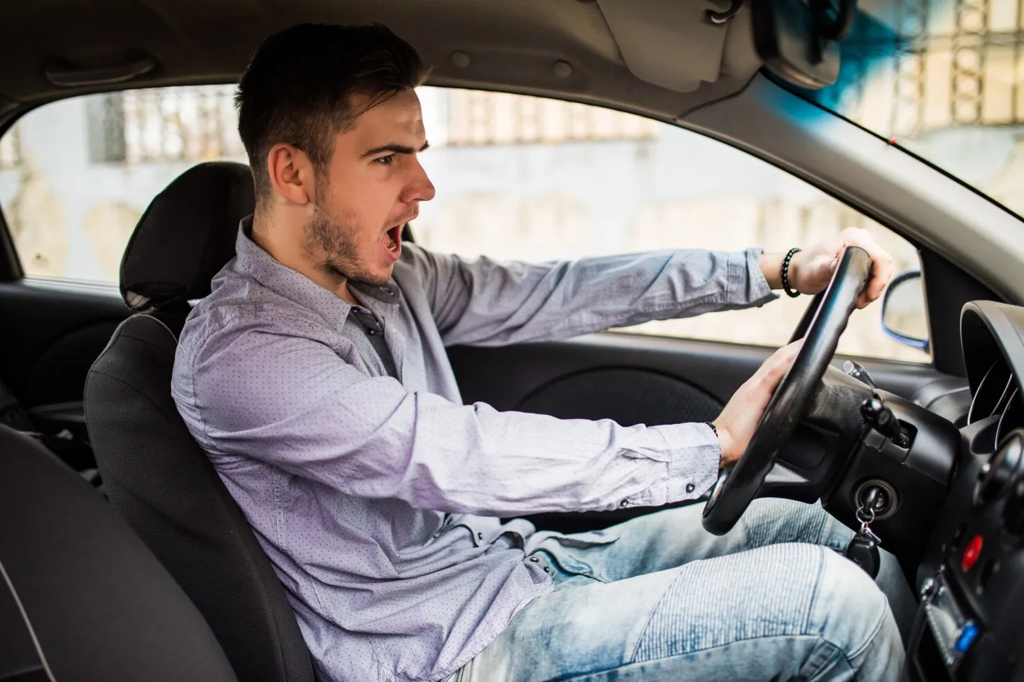 Dangerous Driving Driver shouting while gripping steering wheel, representing dangerous driving.