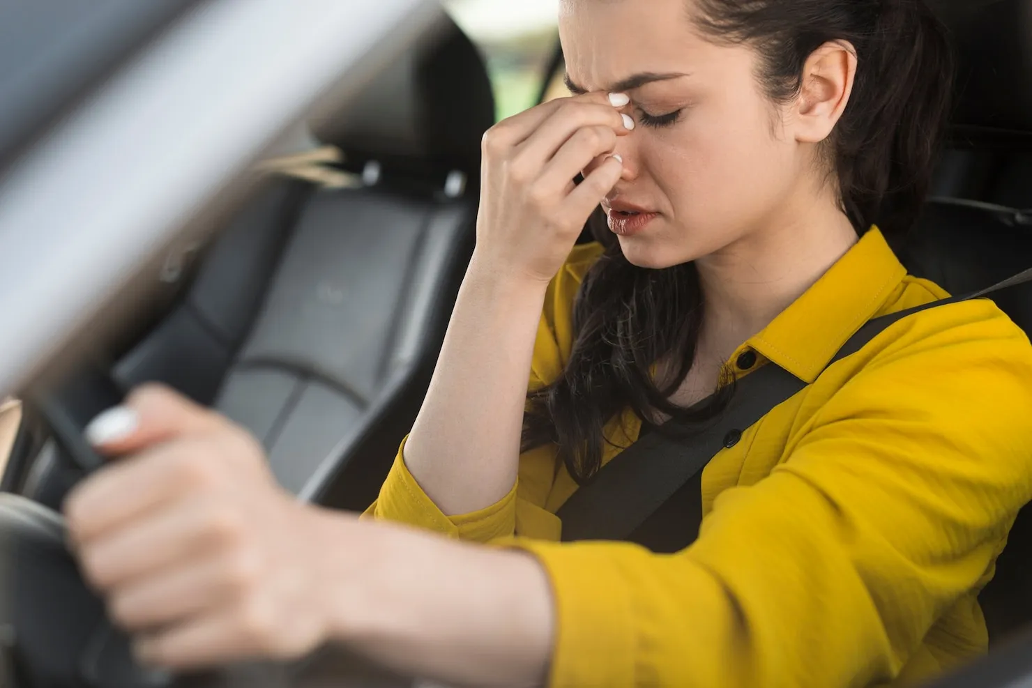 Distressed driver holding steering wheel with eyes closed